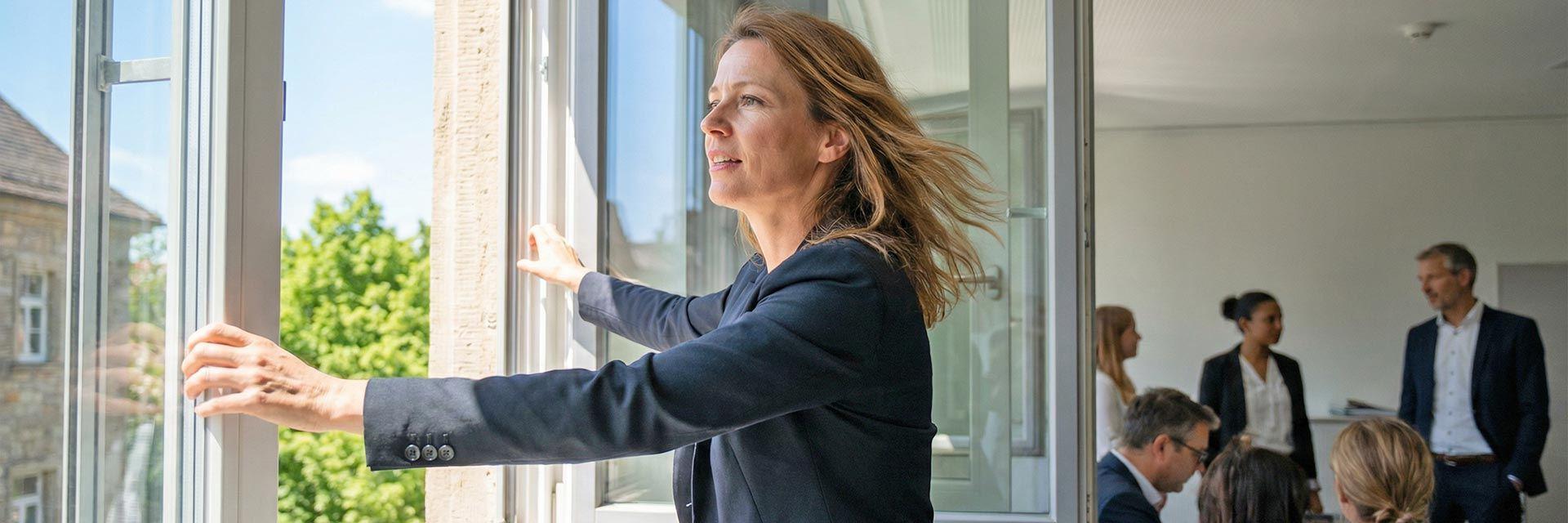 Frau öffnet Fenster im Büro – Frühjahrscheck für Fachkräfte im Landkreis Ravensburg
